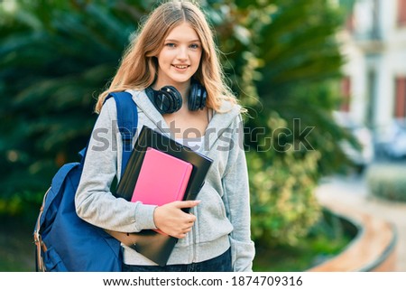 Beautiful caucasian student teenager smiling happy using headphones at the park.