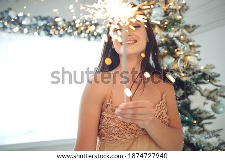 A woman with a sparkler at Christmas. High quality photo.
