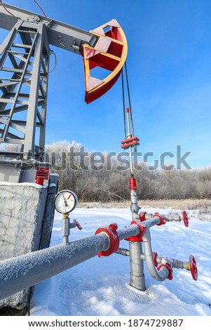 Oil pressure gauge shows 10 ATM (Max 15 Bar - red line). Oil pumpjack winter work. A pumpjack is the overground drive for a reciprocating piston pump in an oil well.