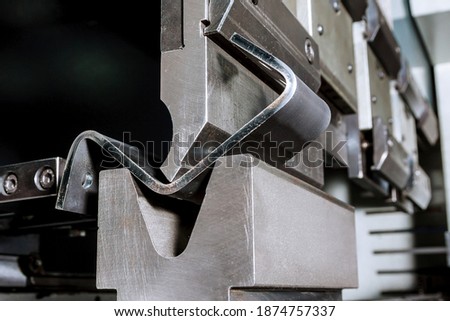 The process of bending sheet metal on a hydraulic bending machine Royalty-Free Stock Photo #1874757337