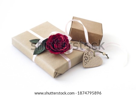 gift boxes, red rose, carved wooden heart on a white background