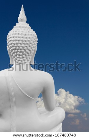 Some behind the White Buddha with blue clouds in the background.
