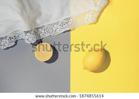 Fresh lemons and white fabric cloth on colorful background. Beautiful backdrop for cards, blogs, posters and web design. Selective focus.