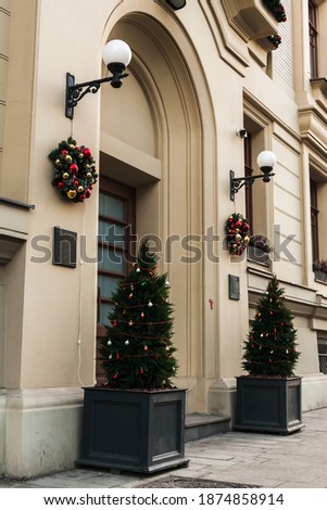 Christmas streets European architecture. decorations on the facades of buildings. Christmas trees, decorative wreaths with balls.Festive background. Happy Holidays and New Year greeting card, banner