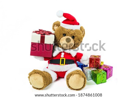 A teddy bear doll wearing santa set, carry gift box  isolated on white background,Christmas day and New Year's gifts
