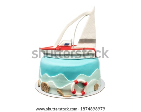 A marine-themed cake, a sugar paste sailboat for a boy's birthday. On a white isolated background.