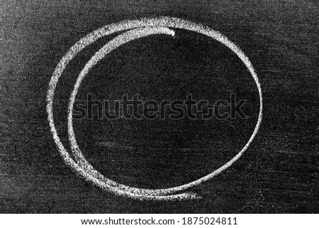 White color chalk hand drawing in circle or oval shape on black board background