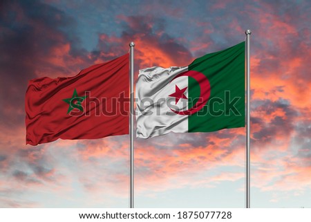 Flag of Morocco and Algeria waving together in the blue sky