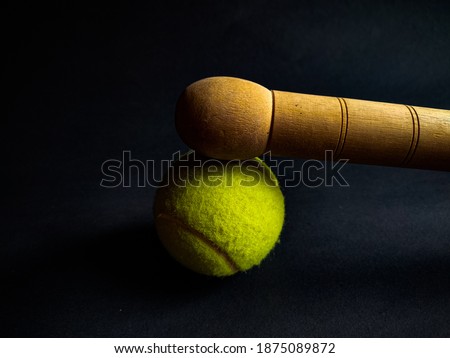 tennis ball with wooden baseball bat