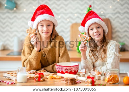 Little girls cooking Christmas gingerbread. Baking and cooking with children for Christmas at home. Merry Christmas and Happy Holidays