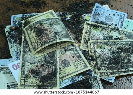 On the table are dollars stained with earth, symbolizing illegal earnings. High quality photo