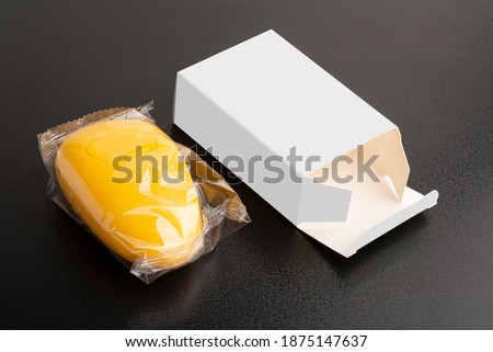 Opened yellow soap package on black surface, editable mock-up series template ready for your design, box faces selection path included.