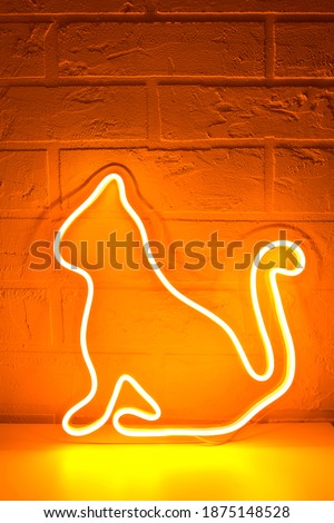 Neon sign yellow cat in the decor. Merry Christmas background. New Year. Trendy style. Neon sign. Custom neon. Home decor.
