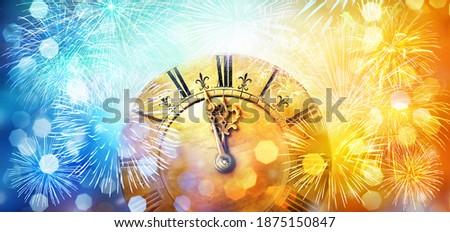 Blue and yellow circular reflections and a clock showing the beginning of the New Year. Blurred light of Christmas and New Year. Winter abstract background defocused.