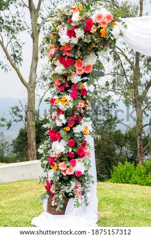 Arch decorated with flowers and white fabric for taking pictures in outdoor ceremony, outdoor wedding decoration.