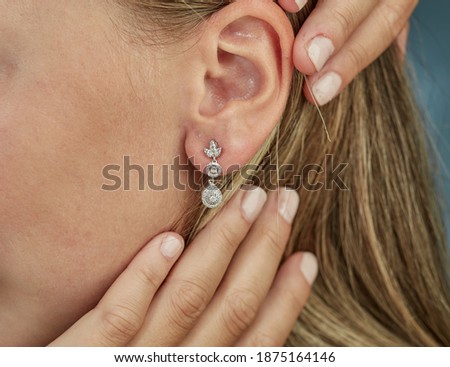 Diamond earringa on young women hand