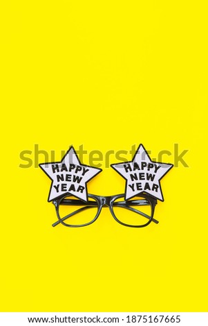 Happy new year glasses on yellow background, top view