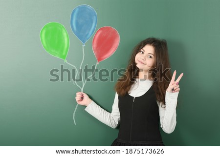 Portrait of pre-adolescent child is holding a bunch of  painted balloons. High resolution photo. Full depth of field.