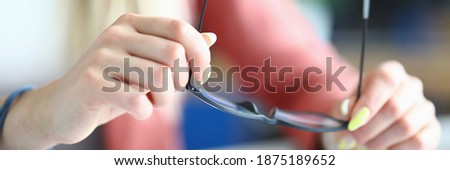 Close-up of female holding black stylish glasses. Detailed picture of trendy accessory. Cabinet worker in beautiful pink jacket. Business meeting and career growth concept