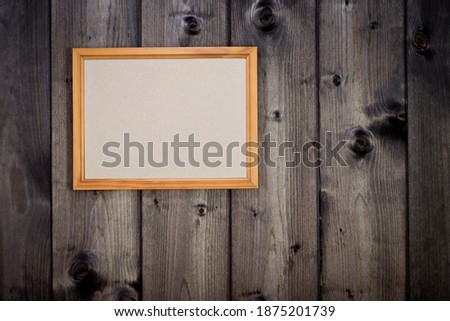 Mock up empty wooden picture frame on dark pine wood wall background, show text or product.
