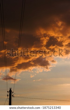 clouds at sunset and power line pillar
