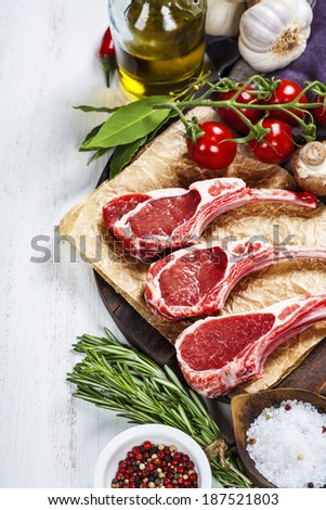 Raw lamb cutlets with vegetables, herbs and spices