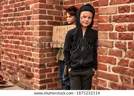 two caucasian homeless boys begging in city streets, suffering from poverty and loneliness, want to find shelter and food donation