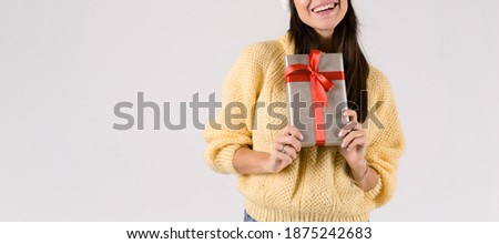 Christmas concept. Woman's hands showing beautiful christmas gift box with red bow - closeup of present on white background. Banner size