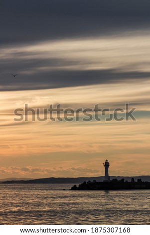 Kushiro Port Lighthouse where the silhouette is projected in the orange sky at sunset