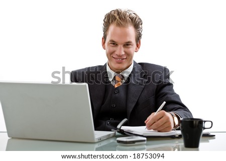 Businessman working on laptop computer, smiling, white background