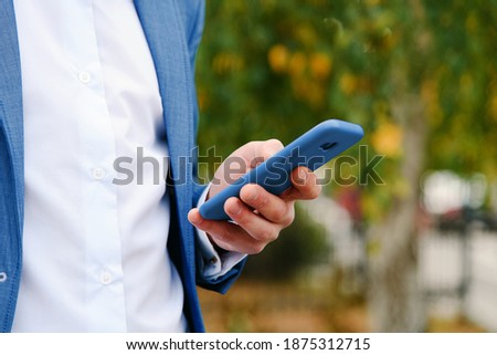 Man use smartphone outdoor in his hand, close up view on hand with phone