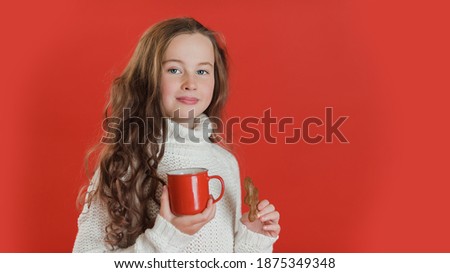 Child with red cup of hot cocoa or chocolate with marshmallow on bright red vivid color background. christmas and people concept. New Year Happy holidays. kid satisfied with present