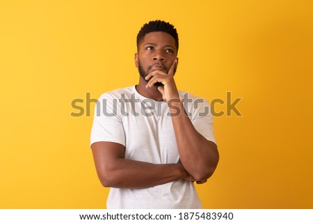 afro man thinking on yellow background with space for text Royalty-Free Stock Photo #1875483940