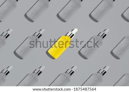 Illuminating Yellow glass serum bottle pattern on Ultimate Gray background. Cosmetic pipette dropper mock up. Creative design colors of the year 2021