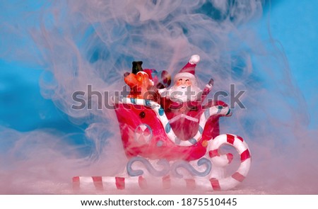 Toy Santa Claus, a cute dog, colorful presents in a sleigh, which is gliding through some heavy fog.
  Dry ice simulates the fog.
Bright cheerful colors.