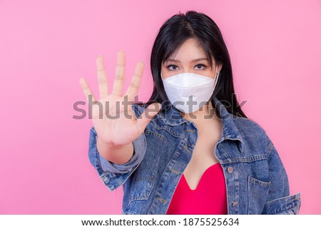 Asian girl wearing Face Mask show stop hands gesture for stop corona virus outbreak , protect spread Covid-19 