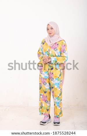 Portrait of  beautiful young girls wearing colorful pyjamas isolated over white background. Tie dye fashion.