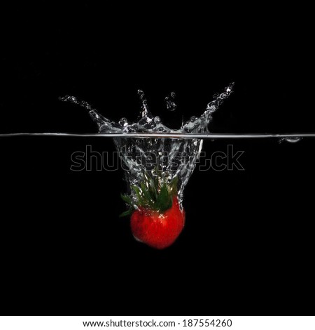 Strawberry in water on a black background.