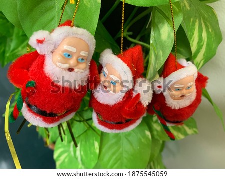 Santa Claus doll Was hung on a plastic tree with a light green background. Christmas Concept