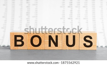 bonus word written on wood block on the background of columns of numbers. bonus text on wooden table for your desing, concept