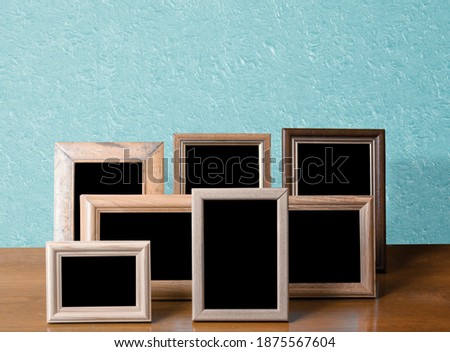 wooden photo frames on table, blue wall