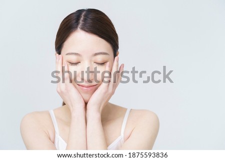 Asian woman touching her face Royalty-Free Stock Photo #1875593836