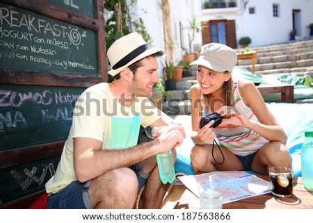 Couple of tourists relaxing and checking on pictures