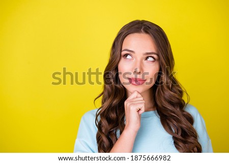 Photo of lovely dreamy young girl hand chin smiling imagining look up copyspace make choice seeing promising opportunity wear blue pullover isolated bright yellow color background