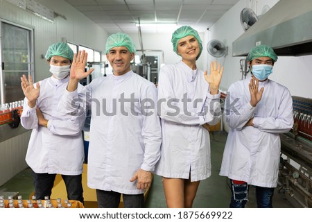 portrait factory worker team raise hand up post in beverage factory