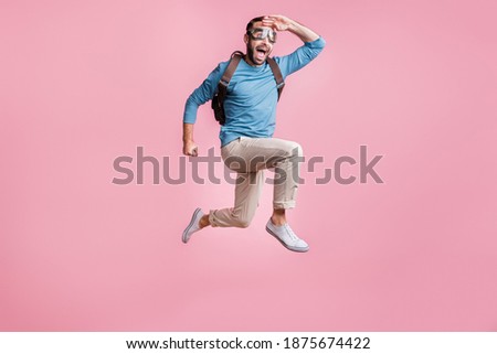 Full length photo of cute guy wear pullover glasses backpack skydive arm head looking far away isolated pink color background Royalty-Free Stock Photo #1875674422