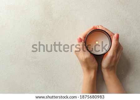 Female hands holding scented candle, top view Royalty-Free Stock Photo #1875680983