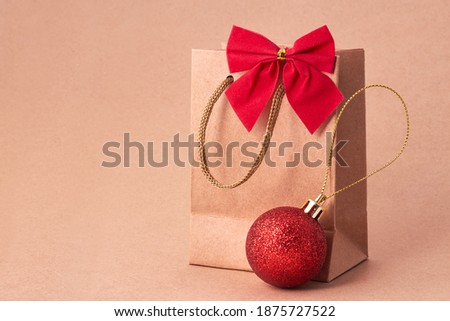 Christmas package with a red bow and a red ball on a brown background.