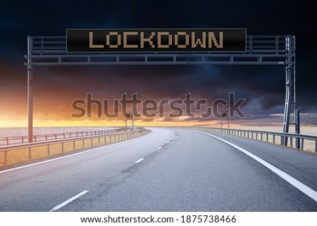 Highway with information board on a background pf dramatic sky. Caption "LOCKDOWN"