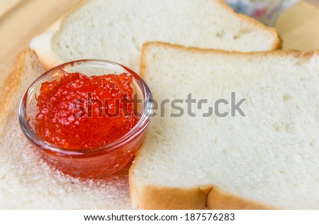 strawberry jam with many bread on wood pattern background